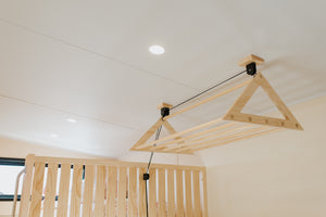 Pulley Laundry Rack. It helps free up floor space and get wet clothes out of your eye-line, it also helps the clothes dry faster by pulling them into the warmer ceiling air! Photo pictured inside one of BuildTiny's Tiny Homes.